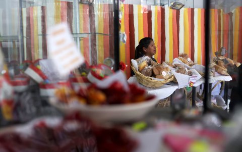 Una mujer ordena sus productos en una exposición de emprendedoras, el 22 de mayo de 2024 en La Paz (Bolivia).