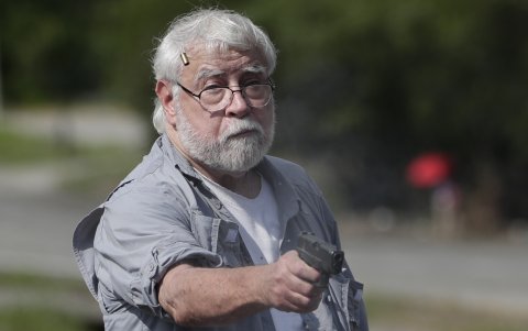 El panameño Kenneth Darlington mientras dispara un arma hacia un manifestante en medio de un bloqueo de docentes en la vía Panamericana, en Chame (Panamá).