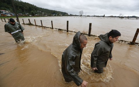 Socorritas recorren una zona inundada tras el desborde del río Pichilo, producto de las fuertes lluvias, este martes en el sector Los Guzmanes