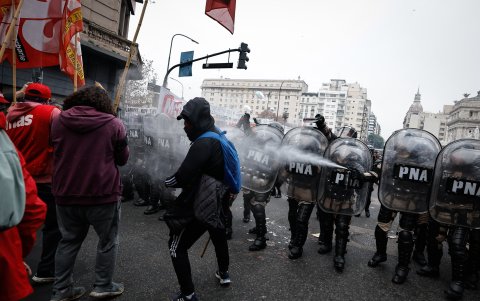 Policías lanzan agua durante enfrentamientos entre la policía y personas que protestan a las afueras del Senado.