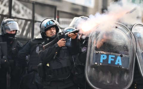 Policías disparan gases lacrimógenos durante enfrentamientos entre la policía y personas que protestan a las afueras del senado durante un debate este miércoles, en Buenos Aires (Argentina).
