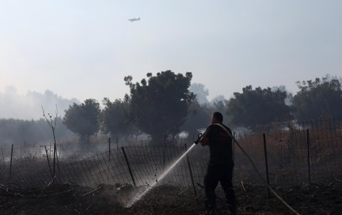 Un bombero apaga un incendio cerca de Safad, al norte de Israel, el 12 de junio de 2024, provocado por cohetes disparados desde el Líbano.