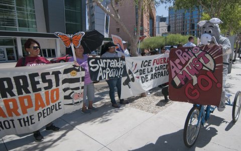 Personas sostienen pancartas que piden el arresto del alguacil Arpaio, acusado de prácticas de discriminación racial en contra de latinos, el 31 de mayo 2016, en la corte federal en Phoenix, Arizona.