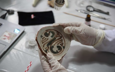 Una persona realiza trabajos de restauración de objetos arqueológicos en el nuevo aeropuerto de Lima.