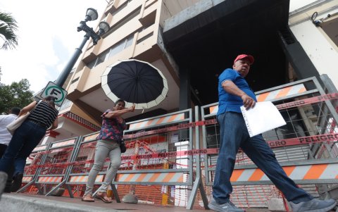 Quienes pasan por debajo de la estructura se cubren con paraguas, por temor.