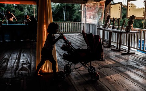 Una niña indígena jugando con un coche en una cabaña en Iquitos (Perú).