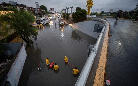 Personal de Protección Civil, en la ciudad de Monterrey (México), trabajan en un desnivel inundado debido a las fuertes lluvias este miércoles.