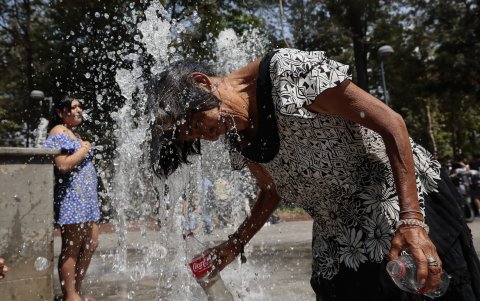 Una mujer que se refresca en una fuente pública, debido a las altas temperaturas registradas en la Ciudad de México (México).