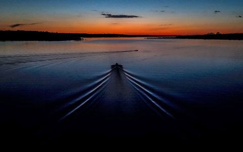 Un barco en las aguas del río urubu durante el atardecer, el 14 de junio del 2024, en la selva amazónica (Brasil).