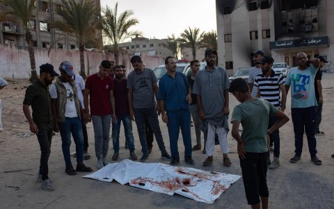 Familiares palestinos lloran junto al cuerpo de un familiar que murió en un ataque militar israelí que tuvo como objetivo un campamento en la zona de Al-Mawasi.