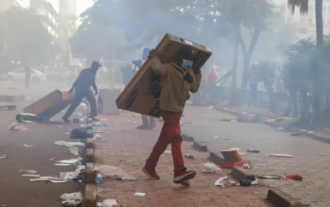Un hombre lleva un televisor saqueado en una tienda cercana durante una protesta cerca del Parlamento contra los aumentos de impuestos, en Nairobi, Kenia, el 25 de junio de 2024.