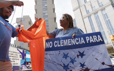 Una mujer sostiene una pancarta que pide 