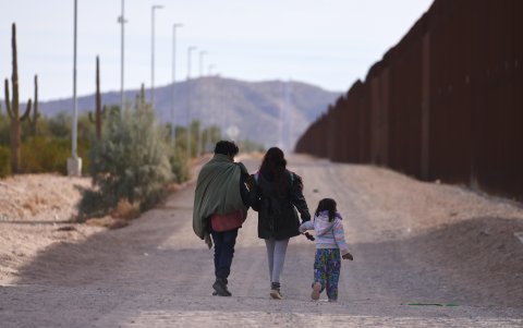 Una familia camina a lo largo del muro fronterizo de Estados Unidos buscando a la Patrulla Fronteriza estadounidense para entregarse para su procesamiento en Lukeville, Arizona, Estados Unidos.