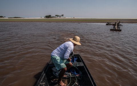 Pescadores transitan por una parte baja de caudal de agua del Río Negro, en el Amazonas (Brasil).