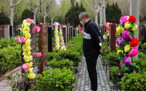 Un hombre frente a una tumba en el Cementerio Waiqiao en Pekín.