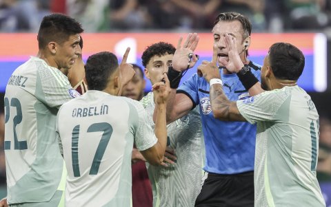 Jugadores mexicanos hablando con el árbitro durante el partido con Venezuela.