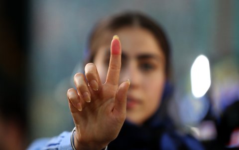 Una chica iraní enseña su dedo manchado de tinta después de votar en Teherán para las elecciones presidenciales.
