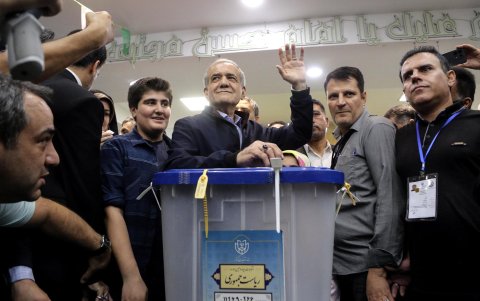 El candidato presidencial reformista iraní Masoud Pezeshkian (c) saluda mientras emite su voto en un colegio electoral durante las elecciones presidenciales en Teherán, Irán, el 28 de junio de 2024.