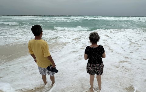 Dos personas observan el oleaje debido a la proximidad de la tormenta tropical 'Beryl' este sábado, en Cancún