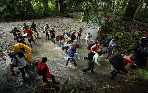 Un grupo de personas atraviesan una zona boscosa en el llamado Tapón del Darién.