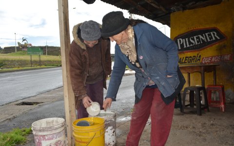 Lida y su hija recogen el agua en baldes para no padecer para los quehaceres del hogar.