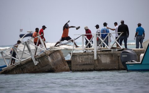 Hombres caminan por uno de los muelles destruidos en la Marina ZarPar, tras el paso del huracán Beryl, este miércoles, en Boca Chica (República Dominicana).