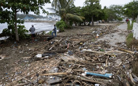Hombres caminan por uno de los muelles destruidos en la Marina ZarPar, tras el paso del huracán Beryl, este miércoles, en Boca Chica (República Dominicana).
