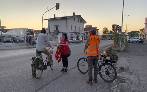 Sindicalistas de la CGIL entregan información sobre derechos sindicales a un migrante indio que se dirige a trabajar a los campos de la zona.