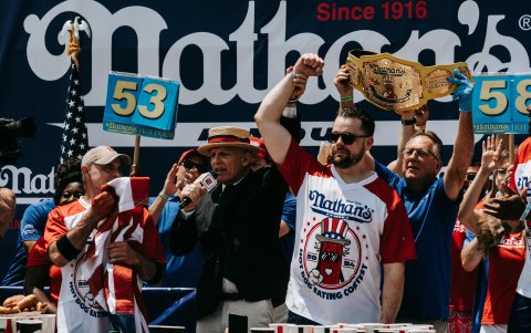 Patrick Bertoletti (c) es declarado ganador durante el famoso concurso internacional de comer perritos calientes del 4 de julio de Nathan, en Coney Island, en el distrito de Brooklyn.