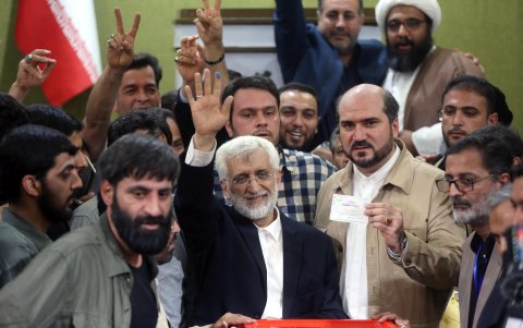 El candidato presidencial Said Jalili (c) saluda tras depositar su voto en un colegio electoral.