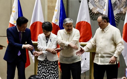 El ministro de Defensa japonés, Minoru Kihara y el ministro de Relaciones Exteriores, Kamikawa Yoko, se toman del brazo durante una reunión ministerial en Manila.