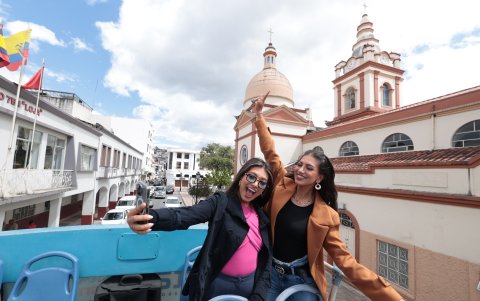 El bus turístico dos personas se toman fotos al pasar por una de las iglesias