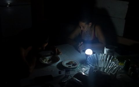 Una familia cenando a oscuras durante un apagón en La Habana