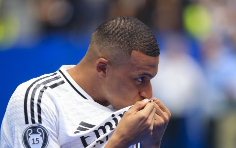 El francés Kylian Mbappé besa el escudo del Real Madrid durante su presentación como nuevo jugador del club.