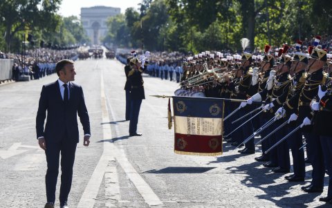 El presidente Emmanuel Macron (i), pasa revista a las tropas durante el desfile militar del Día de la Bastilla en la avenida Foch con el Arco de Triunfo al fondo, en París, el 14 de julio de 2024.