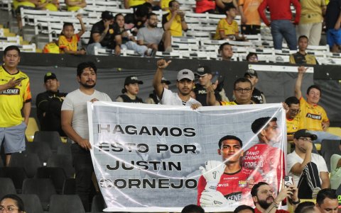 Hinchas con un cartel que prometieron llevar en los demás partidos en homenaje a Justin Cornejo.