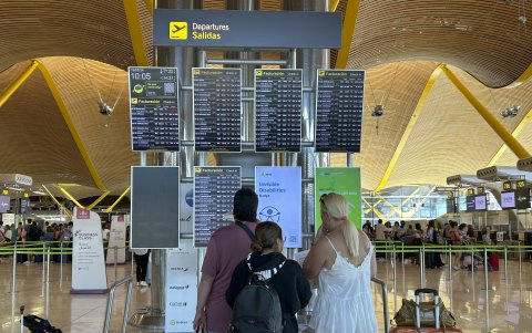 Varias personas miran las pantallas de información de la T-4 del Aeropuerto Adolfo Suárez de Madrid tras la incidencia global de Microsoft que ha afectado a numerosas empresas en todo el mundo.