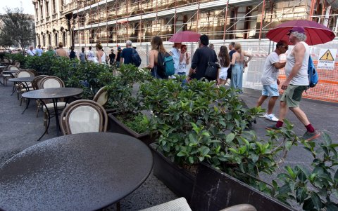 Varias personas caminan por una avenida de Catania, en un espacio urbano concurrido.