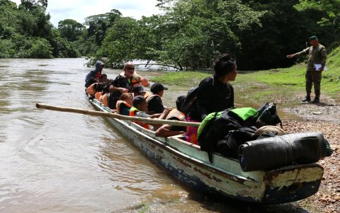 Un grupo de migrantes atraviesa un canal de Panamá.