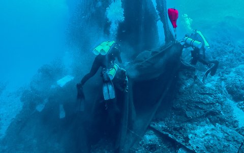 Un grupo de submarinistas intentan levantar hacia la superficie parte de la 'pesca del día'.