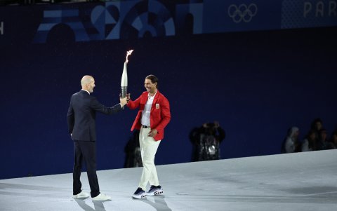 El tenista español Rafa Nadal (d) recoge la antorcha olímpica de manos del exfutbolista Zinedine Zidane en la Plaza del Trocadero.