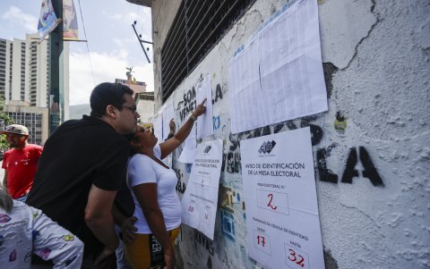 Ciudadanos venezolanos buscan su mesa de votación durante la jornada de elecciones presidenciales de Venezuela este domingo, en Caracas (Venezuela).