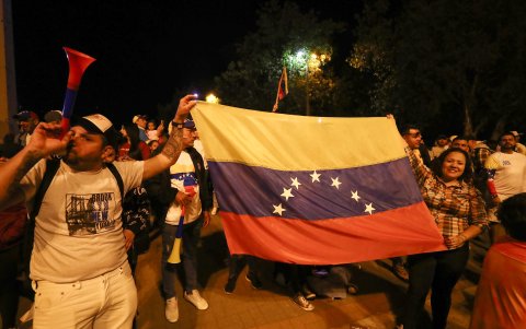 Ciudadanos venezolanos se reúnen a la espera de los resultados de las elecciones presidenciales en su país, este domingo en Quito (Ecuador).