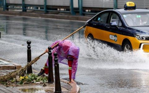 Un limpiador trabaja en una calle durante fuertes lluvias en Beijing, China, 30 de julio de 2024.