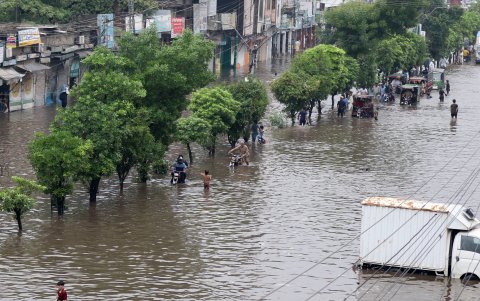 Decenas de personas transitan por una avenida inundada tras las fuertes lluvias que cayeron en Lahore (Pakistán), el 1 de agosto de 2024.
