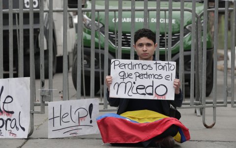 Un ciudadano venezolano sosteniendo un cartel afuera de la embajada de Venezuela,en el barrio de Providencia en Santiago (Chile).
