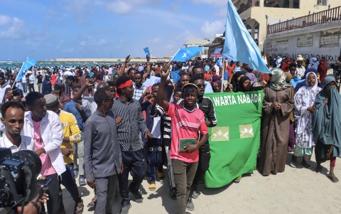 El pueblo somalí ondea banderas nacionales mientras se reúne en la playa de Lido para denunciar la violencia y llorar a las víctimas del ataque de la semana pasada, en Mogadiscio.