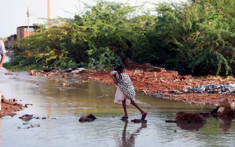 Una persona intenta atravesar una zona rural inundada en este país africano.