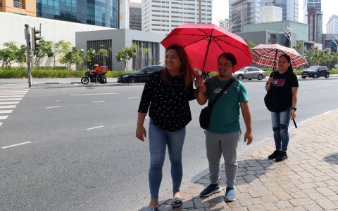 Varias personas se protegen con paraguas del fuerte sol en Dubai.