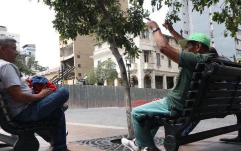 Ellos esperaban por un chance de trabajo en una banca frente al edificio.